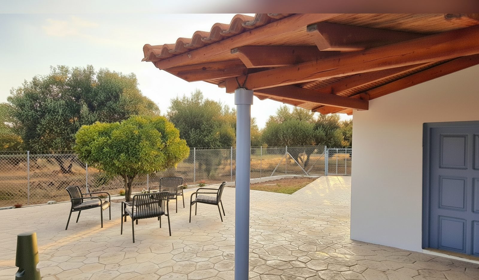 La veranda della casa con i tavolini e l’uliveto sullo sfondo